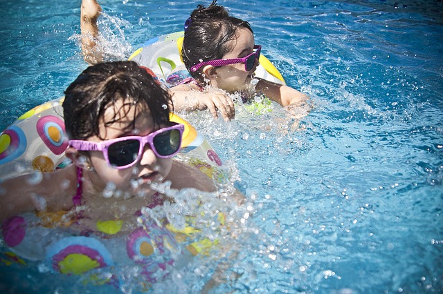 duas crianças brincando na piscina